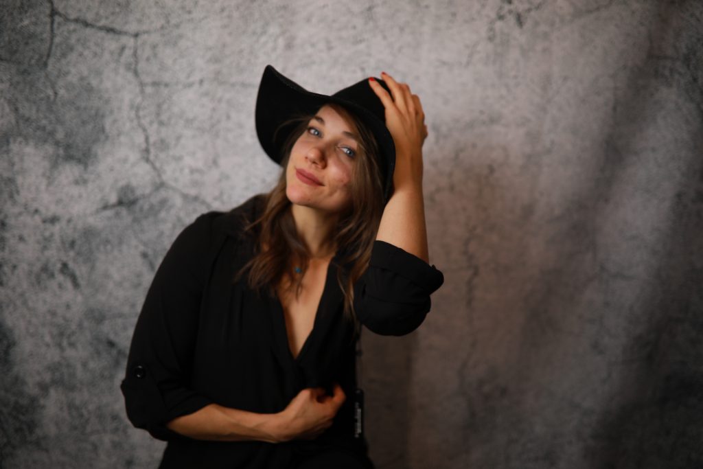 Woman posing in front of a backdrop at a Denver event.