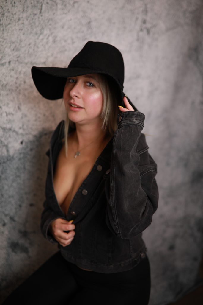 Woman posing in front of a backdrop at a Denver event.