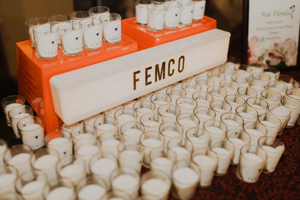 Dozens of white tealight candles with a sign reading femco.