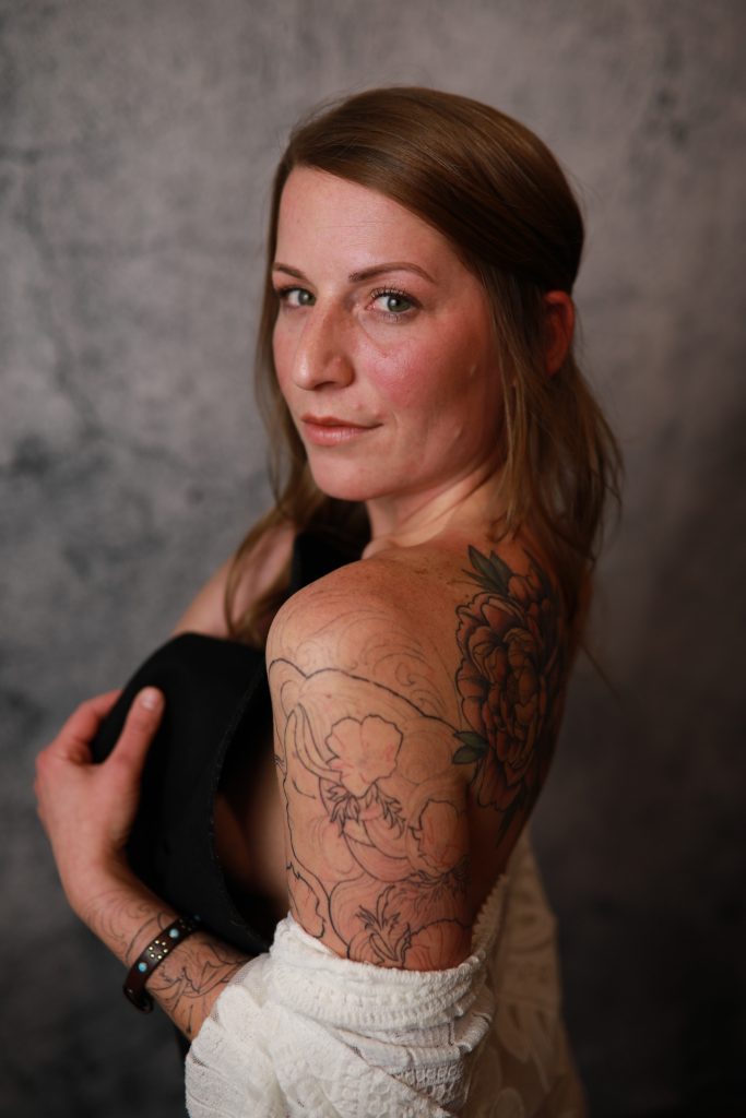 Woman posing in front of a backdrop at a Denver event.