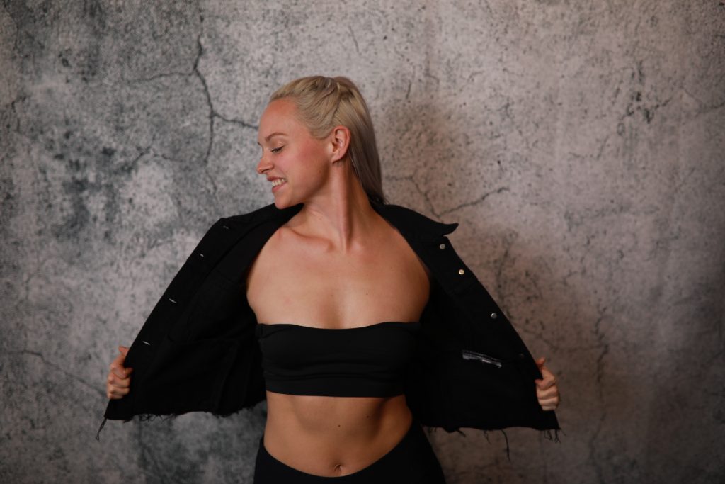 Woman posing in front of a backdrop at a Denver event.