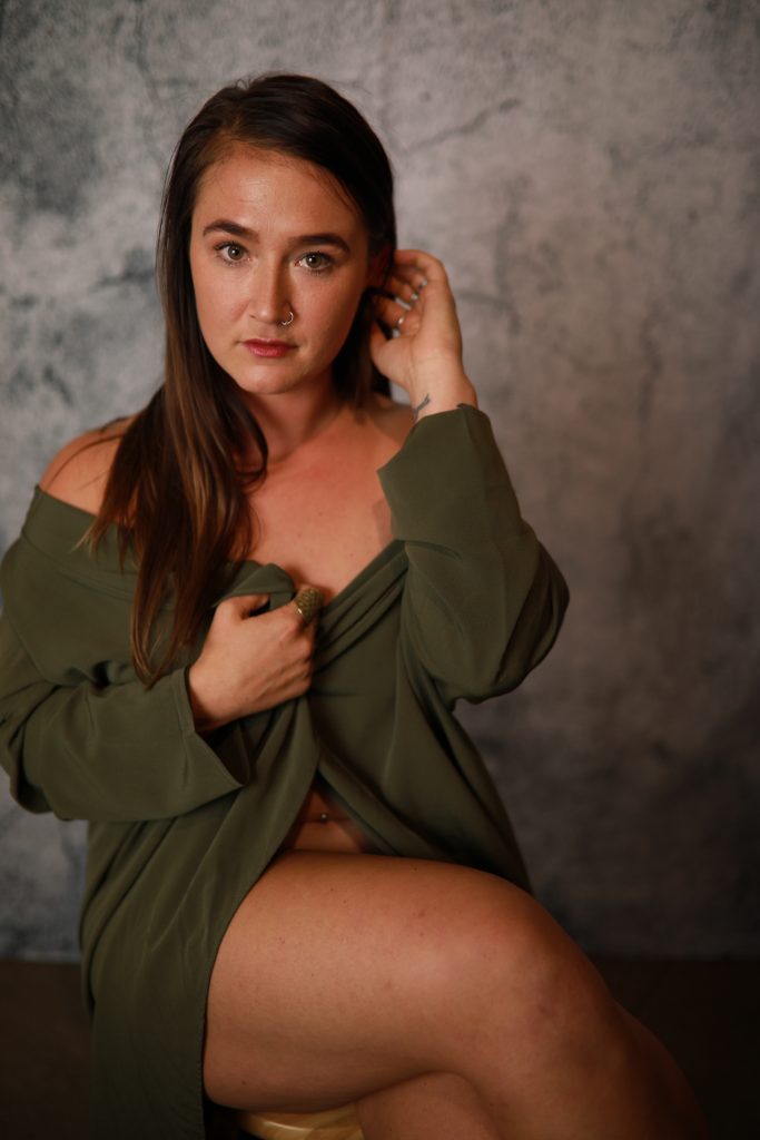 Woman posing in front of a backdrop at a Denver event.