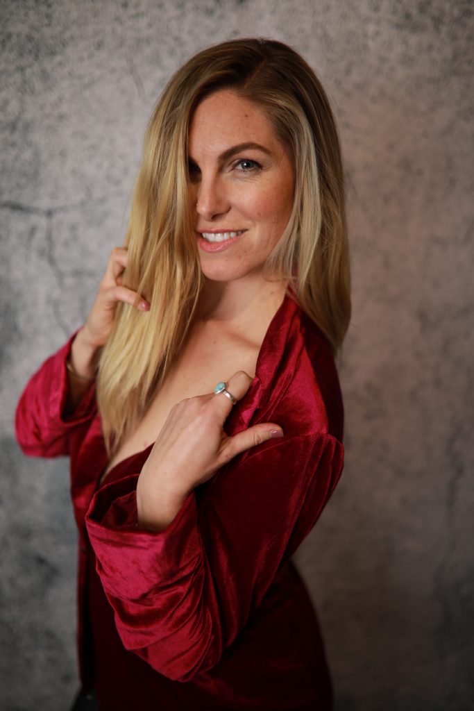 Woman posing in front of a backdrop at a Denver event.