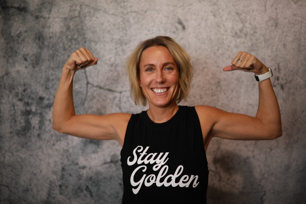 Woman posing in front of a backdrop at a Denver event.