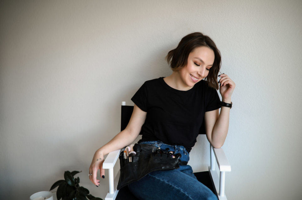 Denver-makeup-artist-posing-on-a-chair-with-their-makeup-belt