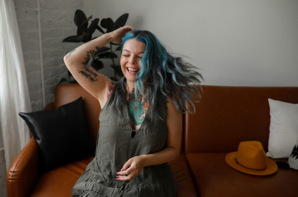 A Denver hairstylist with blue hair and tattoos on her arm.