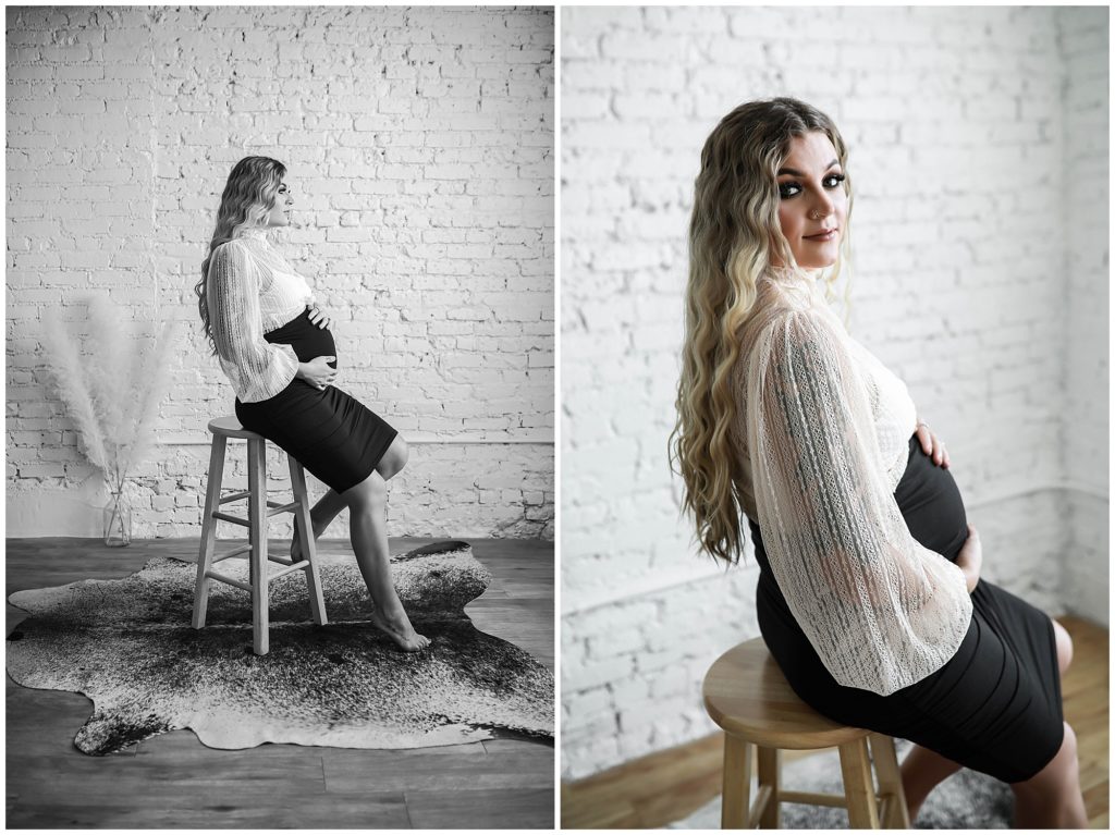 Pregnant woman in shirt and long sleeve lace top posing on stool.