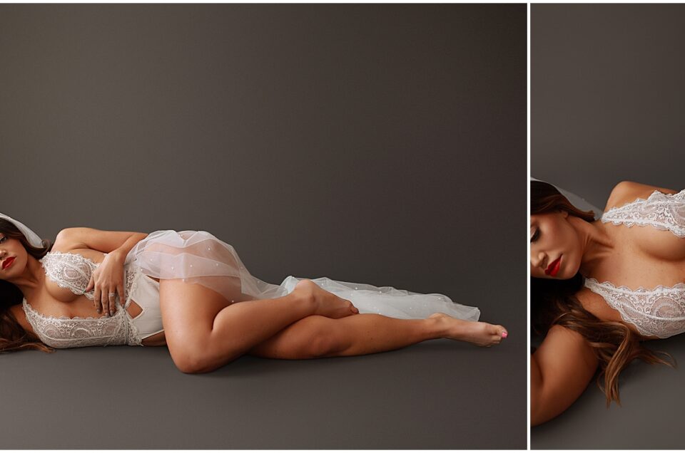 A woman in white bridal lingerie and a veil reclining on a gray background in a Colorado Bridal Boudoir setting.