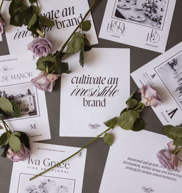 Scattered floral business cards and pink roses on a gray surface, ideal for a brand & marketing strategist.