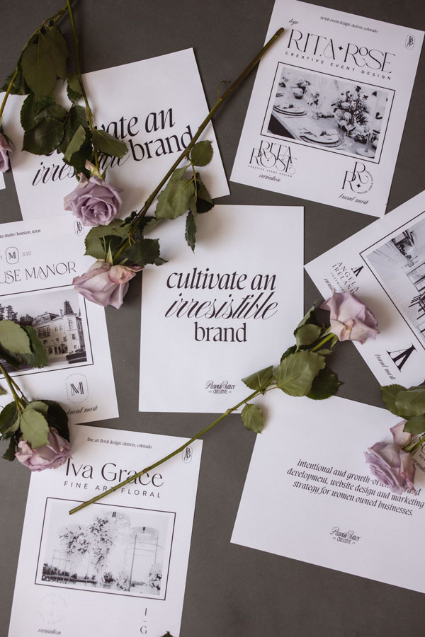 Scattered floral business cards and pink roses on a gray surface, ideal for a brand & marketing strategist.