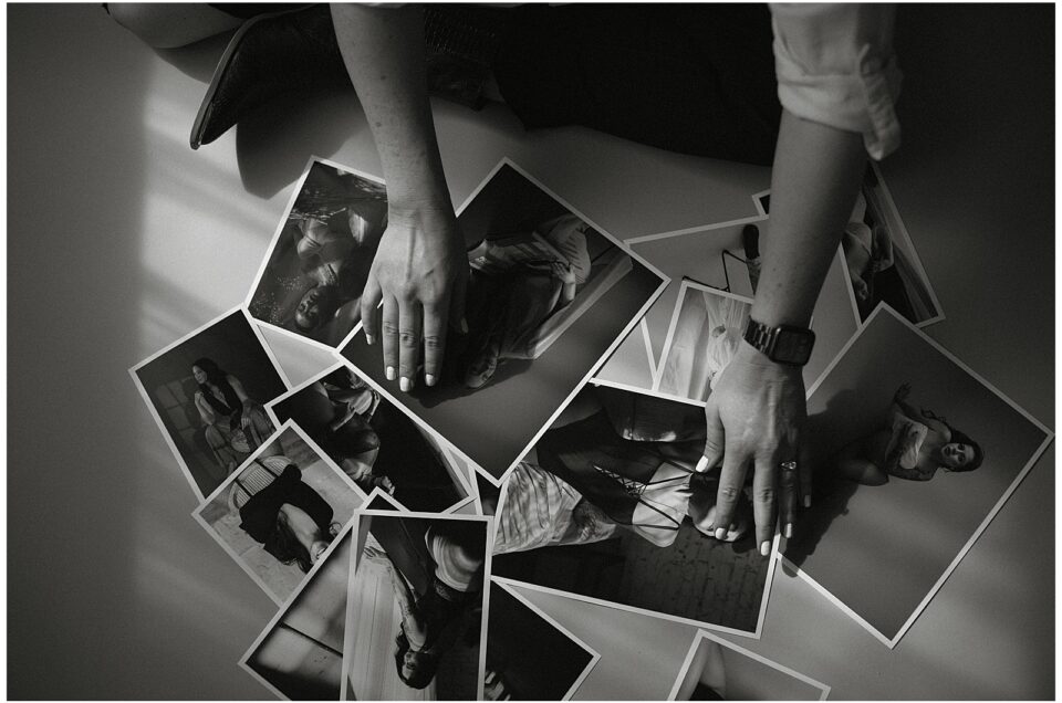 A person with a smartwatch and rings is arranging black and white photographs on a flat surface, showcasing various individuals in different poses. As they carefully place each photo, it’s clear they have many creative ways to work with me.