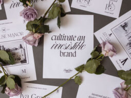 Scattered floral business cards and pink roses on a gray surface, ideal for a brand & marketing strategist.