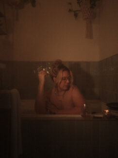 Woman enjoying a relaxing bath by candlelight.